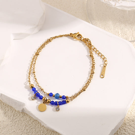 Bracelet Doré Double Chaînes Pierres Bleues Avec Petite Plaque Ronde Et Strass